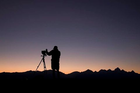 silhouette of student with camera and tripod