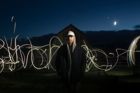 student standing with long exposure lights behind him
