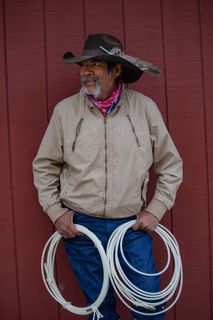 older cowboy holds two lassos