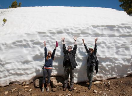 students standing in front of tall snow drift