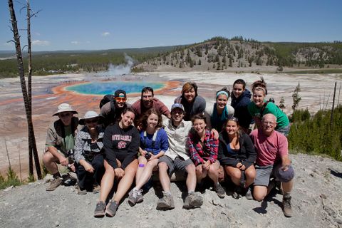 students in front of colorful prismatic pool at yellowstone