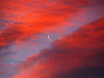 the moon and red clouds at sunrise